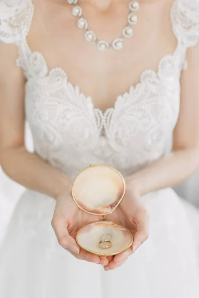 Zarte Hände Der Braut Auf Muschelschachtel Mit Eheringen Hochwertiges Brautfoto Stockbild