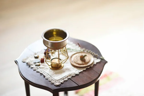 Wooden coffee table with oil warmer with massage candle and decorative objects with copy space