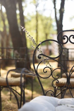 Yaban çiçekli siyah işlemeli demir sandalye, kırsal dikey düğün süslemesi