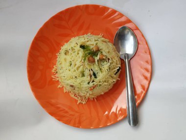 Güzel turuncu renkli seramik plaka, Shavige upma 'lı çelik kaşık ya da beyaz arka planda izole edilmiş yukarı pittu.