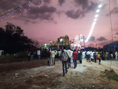 Mandya, Karnataka, Hindistan-Nisan 25, 2023: Kalamma Festivali sırasında bir Kadailavagilu köyünde güzel bir elektrik ışık dekorasyonunun kapatılması ve yanmış ağaç kömürü üzerinde yürüme.