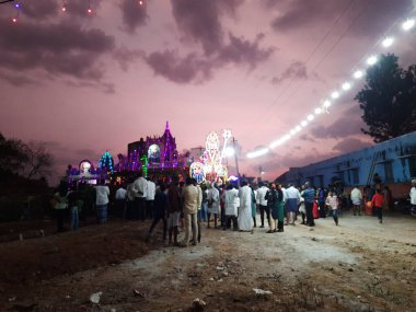 Mandya, Karnataka, Hindistan-Nisan 25, 2023: Kalamma Festivali sırasında bir Kadailavagilu köyünde güzel bir elektrik ışık dekorasyonunun kapatılması ve yanmış ağaç kömürü üzerinde yürüme.