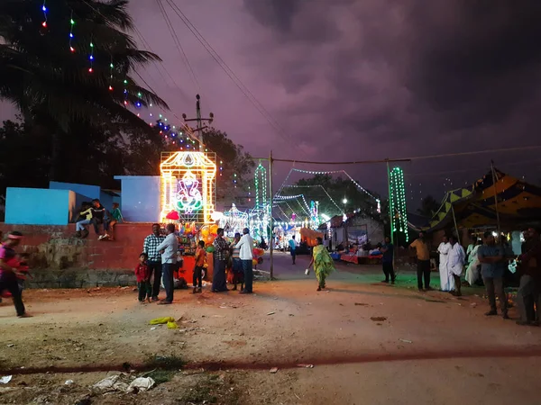 Mandya, Karnataka, Hindistan-Nisan 25, 2023: Kalamma Festivali sırasında bir Kadailavagilu köyünde güzel bir elektrik ışık dekorasyonunun kapatılması ve yanmış ağaç kömürü üzerinde yürüme.