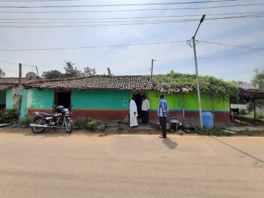 Ramnagar, Karnataka, Hindistan-20 Kasım 2022: Geleneksel Hint köyü aile bireylerinin evinin önünde durması.. Kırsal bölgenin renkli binası.