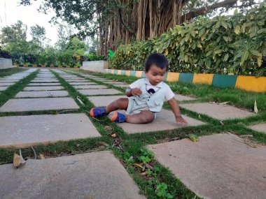 Bangalore, Karnataka, Hindistan-Haziran 10, 2023: Parktaki güzel Hintli Bebek fotoğraf çekimine yakın çekim