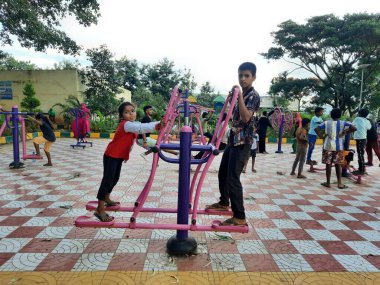 Bangalore, Karnataka, Hindistan-10 Haziran 2023: Makhohalli Ormanı 'ndaki parkta halka açık spor aletleri üzerinde çalışan güzel insanların yakınlaşması