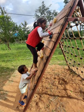 Bangalore, Karnataka, Hindistan-10 Haziran 2023: Parkta ve Machohalli Ormanı Kapısı 'nda birlikte oynayan güzel ve gerçek çocukların spor ekipmanlarına yakın çekim