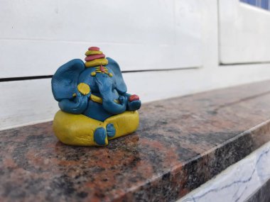 Renkli küçük ya da küçük el yapımı Ganesha kil heykelinin doğal arka planı.