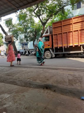 Bangalore, Karnataka, Hindistan-21 Ekim 2023: Hint Anne, büyükanne ve çocuğun yakın çekimi ve yol kenarında büyükannesinin şefkatli torunu.