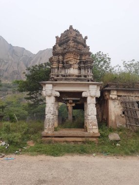 Savanadurga, Karnataka, Hindistan 'da Veerabhadreshwara Swamy Tapınağı' nın aydınlık, eski kule ve büyük taş tepe ve halka açık güzel dini binasının kapatılması..