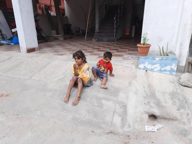 Bangalore, Karnataka, Hindistan-09 Aralık 2023: Sokakta küçük bisikletle abur cubur yiyen Hintli çocuklara yakın çekim.