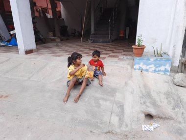 Bangalore, Karnataka, Hindistan-09 Aralık 2023: Sokakta küçük bisikletle abur cubur yiyen Hintli çocuklara yakın çekim.