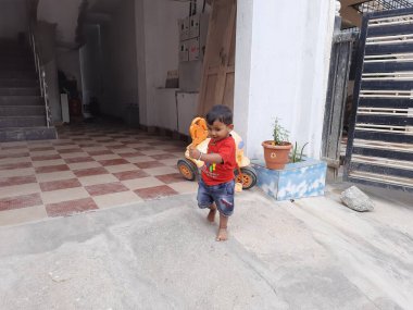 Bangalore, Karnataka, Hindistan-09 Aralık 2023: Sokakta küçük bisikletle abur cubur yiyen Hintli çocuklara yakın çekim.