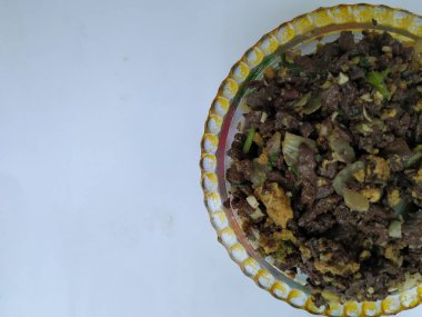 Keçi kanı kızartmasının beyaz arka planda izole edilmiş bir kaptaki yumurtalarla yakın çekimi. Köy Stili Kuzu Kanı Kızarması.