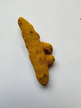 Beyaz bir arka planda izole edilmiş bir grup zerdeçal kökü. Zerdeçal, zerdeçal bitkisinden gelen bir baharattır. Genellikle Asya yemeklerinde kullanılır. Muhtemelen körinin ana baharatı olarak zerdeçal biliyorsunuzdur..