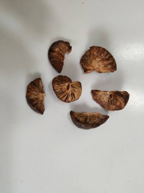 Group of Sliced and Dried Betel/Areca nut. Dried betel nut (Areca catechu) is the fruit of the areca palm (Areca catechu), Usually for chewing, a few slices of the nut are wrapped in a betel leaf along with calcium hydroxide (slaked lime) clipart