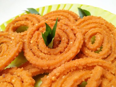 Group and Closeup of Chakli isolated on White Background. Indian Snack Chakli or chakali made from deep frying portions of a lentil flour dough clipart