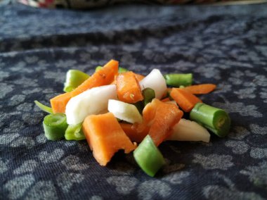 Sebze dilimleri siyah kumaşın üzerine saçılmış. Renkli Sebze Doku ve Arkaplan