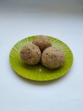 Tambittu ya da pirinç unu laddoo, beyaz arka planda izole edilmiş yeşil renkli bir tabakta. Hint Festivali Ev Yapımı Yemek Festivali..