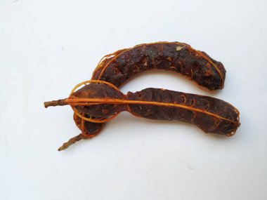 Tropikal demirhindi meyvesine yakın çekim. Kabuğu olmadan soyulmuş, görünür tohumlar ve iç posası var. Beyaz arkaplanda izole