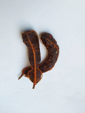 Tropikal demirhindi meyvesine yakın çekim. Kabuğu olmadan soyulmuş, görünür tohumlar ve iç posası var. Beyaz arkaplanda izole