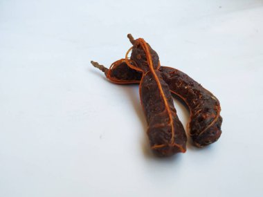 Tropikal demirhindi meyvesine yakın çekim. Kabuğu olmadan soyulmuş, görünür tohumlar ve iç posası var. Beyaz arkaplanda izole