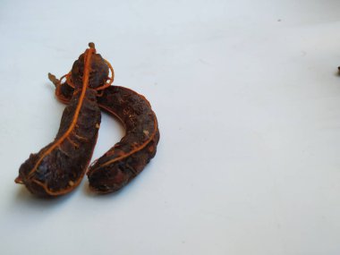 Tropikal demirhindi meyvesine yakın çekim. Kabuğu olmadan soyulmuş, görünür tohumlar ve iç posası var. Beyaz arkaplanda izole