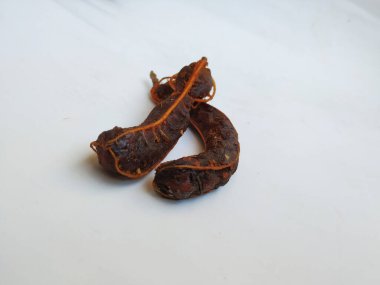 Tropikal demirhindi meyvesine yakın çekim. Kabuğu olmadan soyulmuş, görünür tohumlar ve iç posası var. Beyaz arkaplanda izole