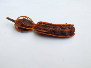 Tropikal demirhindi meyvesine yakın çekim. Kabuğu olmadan soyulmuş, görünür tohumlar ve iç posası var. Beyaz arkaplanda izole