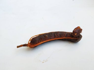 Tropikal demirhindi meyvesine yakın çekim. Kabuğu olmadan soyulmuş, görünür tohumlar ve iç posası var. Beyaz arkaplanda izole