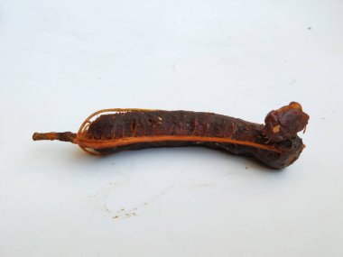 Tropikal demirhindi meyvesine yakın çekim. Kabuğu olmadan soyulmuş, görünür tohumlar ve iç posası var. Beyaz arkaplanda izole