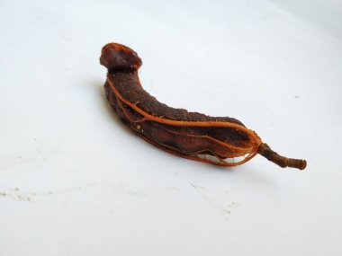 Tropikal demirhindi meyvesine yakın çekim. Kabuğu olmadan soyulmuş, görünür tohumlar ve iç posası var. Beyaz arkaplanda izole