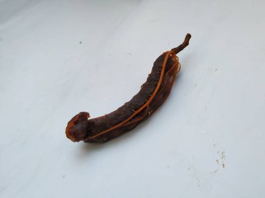 Tropikal demirhindi meyvesine yakın çekim. Kabuğu olmadan soyulmuş, görünür tohumlar ve iç posası var. Beyaz arkaplanda izole