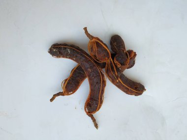 Tropikal demirhindi meyvesine yakın çekim. Kabuğu olmadan soyulmuş, görünür tohumlar ve iç posası var. Beyaz arkaplanda izole