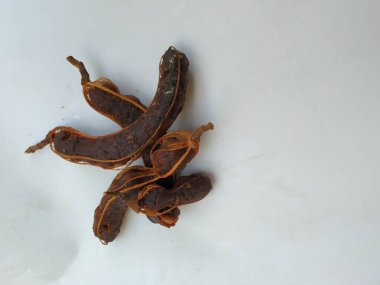 Tropikal demirhindi meyvesine yakın çekim. Kabuğu olmadan soyulmuş, görünür tohumlar ve iç posası var. Beyaz arkaplanda izole