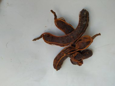 Tropikal demirhindi meyvesine yakın çekim. Kabuğu olmadan soyulmuş, görünür tohumlar ve iç posası var. Beyaz arkaplanda izole