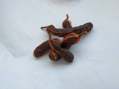 Tropikal demirhindi meyvesine yakın çekim. Kabuğu olmadan soyulmuş, görünür tohumlar ve iç posası var. Beyaz arkaplanda izole