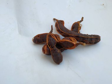 Tropikal demirhindi meyvesine yakın çekim. Kabuğu olmadan soyulmuş, görünür tohumlar ve iç posası var. Beyaz arkaplanda izole