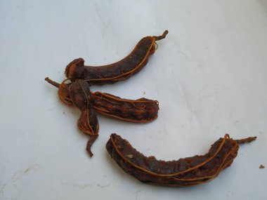 Tropikal demirhindi meyvesine yakın çekim. Kabuğu olmadan soyulmuş, görünür tohumlar ve iç posası var. Beyaz arkaplanda izole