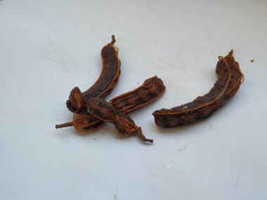 Tropikal demirhindi meyvesine yakın çekim. Kabuğu olmadan soyulmuş, görünür tohumlar ve iç posası var. Beyaz arkaplanda izole