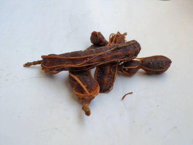 Tropikal demirhindi meyvesine yakın çekim. Kabuğu olmadan soyulmuş, görünür tohumlar ve iç posası var. Beyaz arkaplanda izole