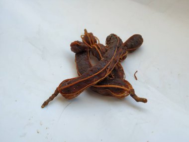 Tropikal demirhindi meyvesine yakın çekim. Kabuğu olmadan soyulmuş, görünür tohumlar ve iç posası var. Beyaz arkaplanda izole