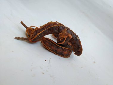 Tropikal demirhindi meyvesine yakın çekim. Kabuğu olmadan soyulmuş, görünür tohumlar ve iç posası var. Beyaz arkaplanda izole