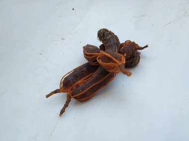 Tropikal demirhindi meyvesine yakın çekim. Kabuğu olmadan soyulmuş, görünür tohumlar ve iç posası var. Beyaz arkaplanda izole