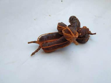 Tropikal demirhindi meyvesine yakın çekim. Kabuğu olmadan soyulmuş, görünür tohumlar ve iç posası var. Beyaz arkaplanda izole