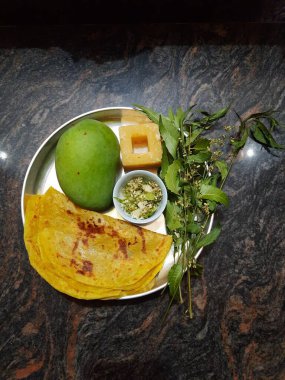 Closeup of beautiful and delicious Ugadi special food like Mango, Jaggery, Neem and Sweet Poli or Obbattu. clipart