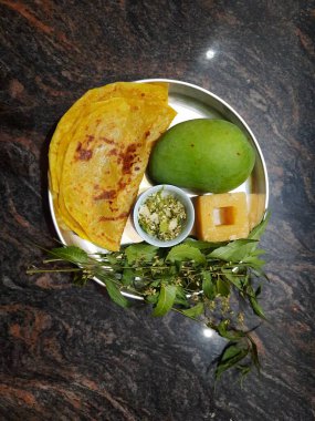 Closeup of beautiful and delicious Ugadi special food like Mango, Jaggery, Neem and Sweet Poli or Obbattu. clipart