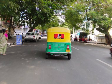 Bangalore, Karnataka, Hindistan-5 Haziran 2024: Sarı ve Yeşil Renkli Otomobil Rickshaw 'ın yakın plan görüntüsü Sinyal' de duruyor. Ünlü Kannada Aktörü Yıldız Darshan 'ın Arkaya Resmini Yapıyor