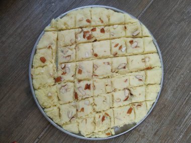 Ev yapımı süt tozu, kare şeklinde dilimlenmiş çelik bir tabakta tatlı..