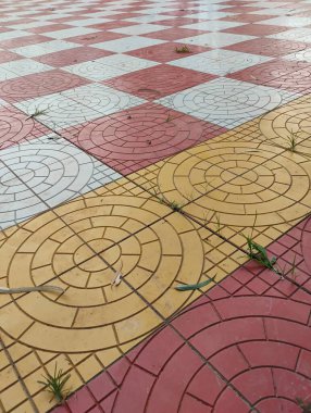Geometrik dairenin ve kare şeklindeki park fayanslarının yakın plan görüntüsü sarı, kırmızı ve beyaz arkaplan